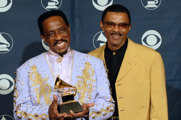 Imagem colorida de Ike Turner segurando um Grammy ao lado do filho Ike Turner Jr.