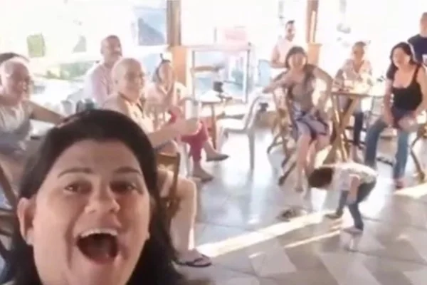 Imagem colorida de família gravando vídeo feliz e criança passando mal de repente. Metrópoles