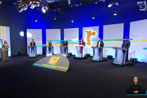 Imagem colorida mostra candidatos alinhados em debate - Metrópoles