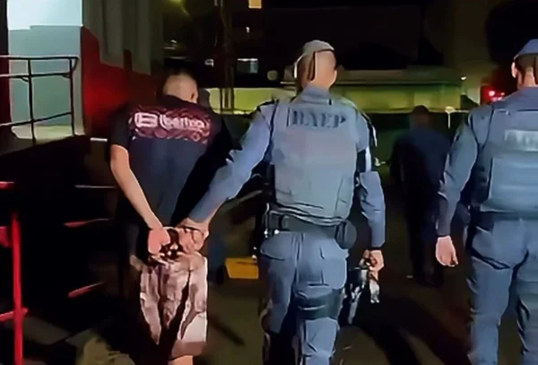 Imagem colorida mostra homem condenado a 182 anos de prisão sendo recapturado pela polícia após fuga