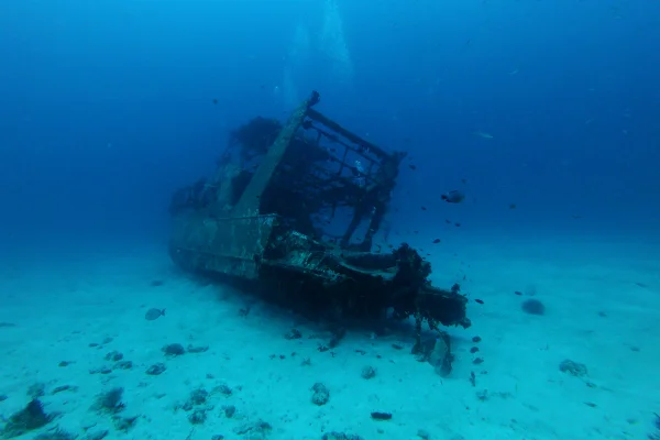 Imagem colorida mostra barco naufragado - Metrópoles