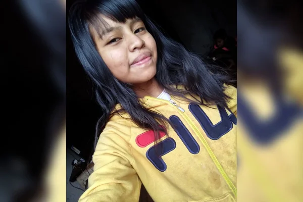 foto colorida de menina indígena com casaco amarelo