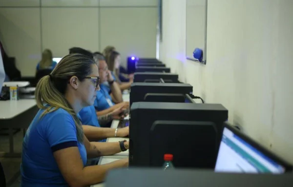 Vários atendentes em frente a computadores-Metrópoles