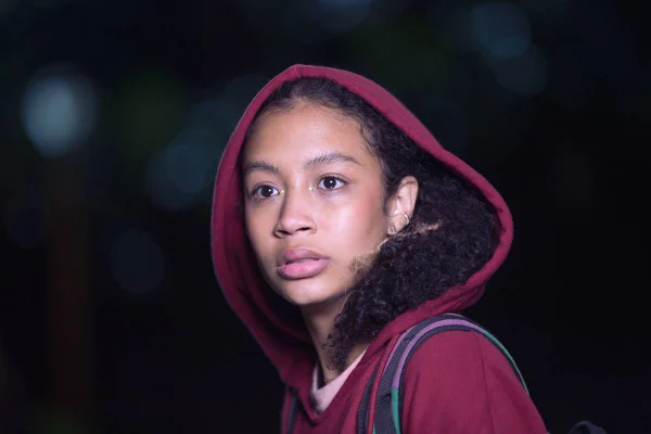 foto colorida de jovem negra de capuz vermelho - metrópoles