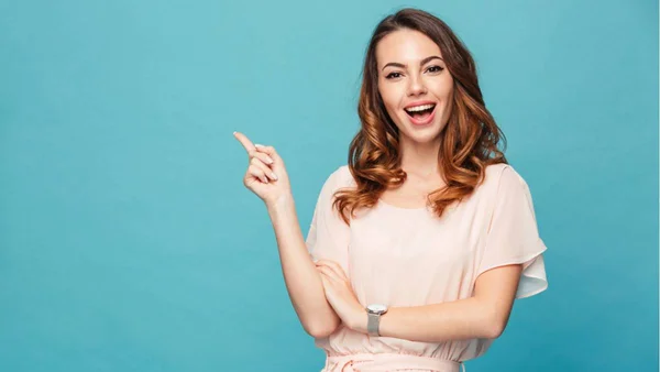 Mulher em fundo azul com o dedo indicador apontado para cima