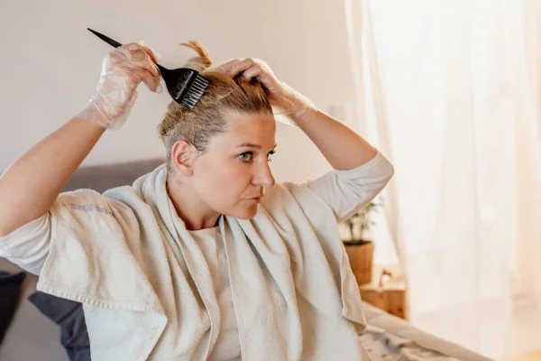 mulher pintando a raiz do cabelo em casa