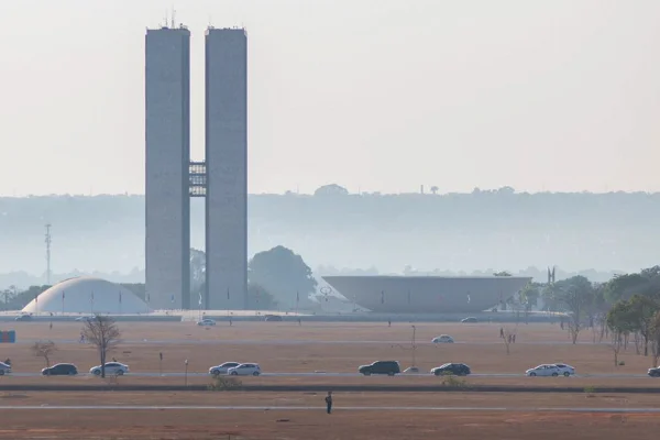 Região central de Brasília, com Congresso Nacional em destaque e gramado seco em frente ao parlamento. Cenário enfumaçado devido à névoa seca e a queimadas nas proximidades. Congresso Nacional ao fundo - Metrópoles