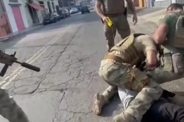 Imagem colorida de policiais em cima de homem preso. Ele se inspirava no Estado Islâmico e planejava um ataque à sede da PF - Metrópoles