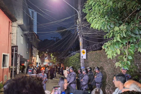 Policiais militares da Tropa de Choque da PM montam cordão de isolamento em rua de comunidade