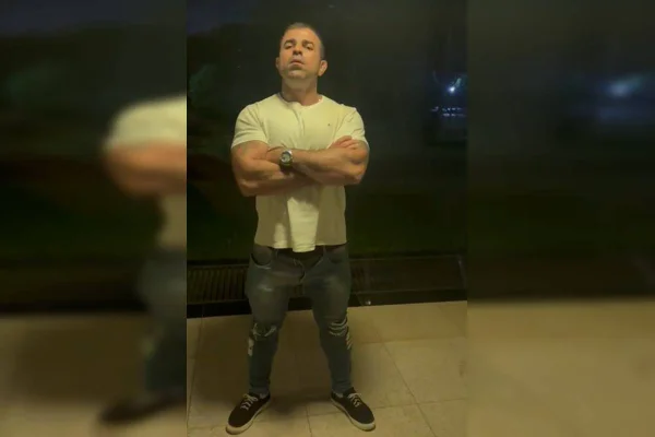 Foto colorida de homem com braços cruzados