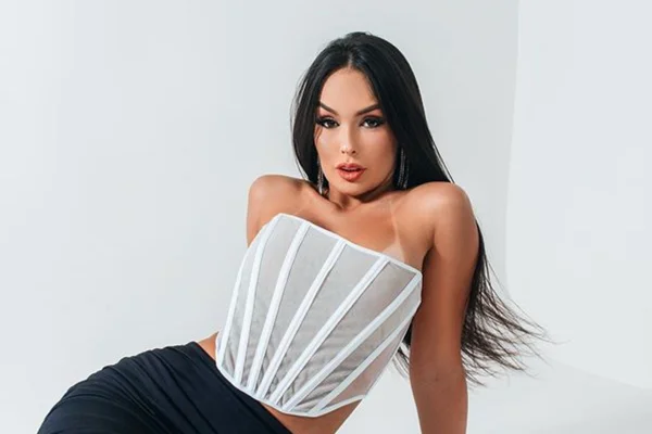Na imagem com cor, a ex-bbb 23 Larissa posa para foto em fundo branco - Metrópoles