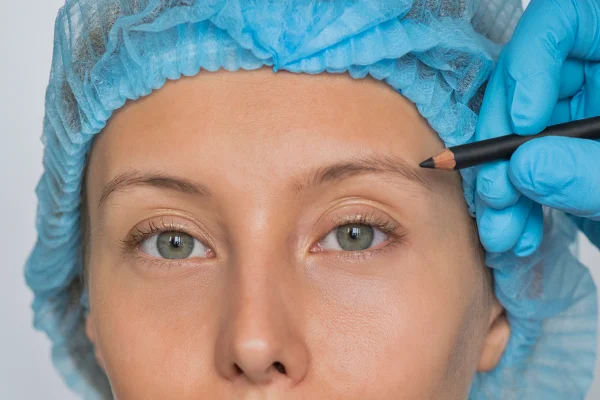 Foto colorida de mulher prestes a passar por procedimento na sobrancelha