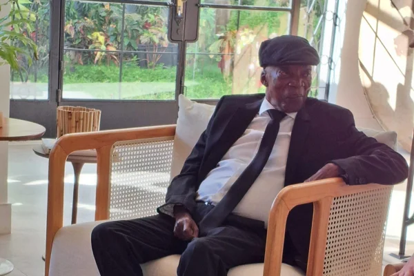 Foto mostra milton nascimento em sua casa no rio de janeiro usando terno e boina preta