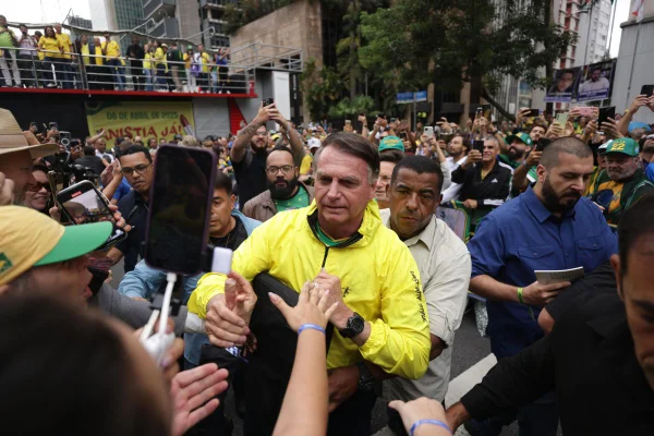 Imagens coloridas mostram ex-presidente Jair Bolsonaro no meio de apoiadores com camisa amarela da seleção brasileira de futebol