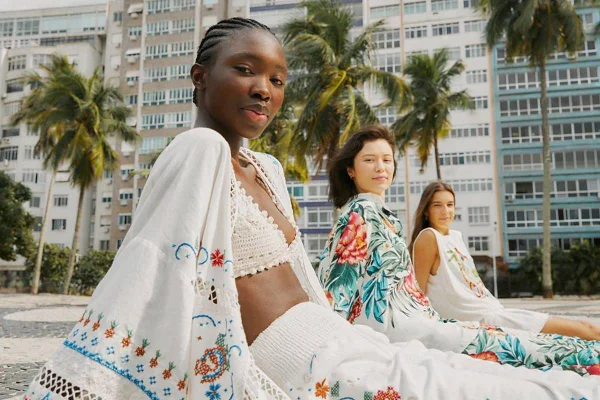 Na imagem com cor, três mulheres sentadas olhando diretamente à camera - Metrópoles
