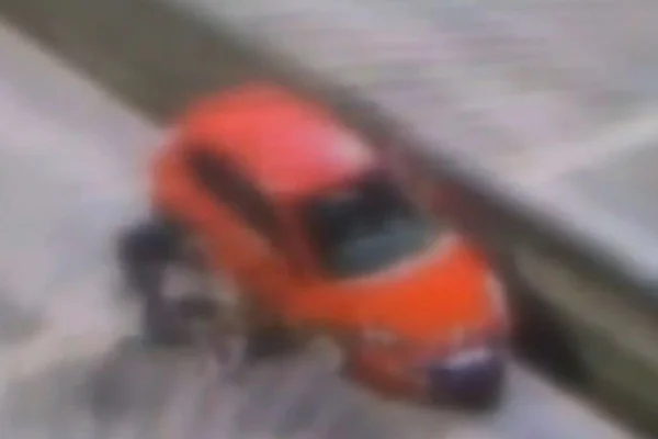 Imagem colorida mostra homem arrastando mulher pelos cabelos perto de um carro vermelho - Metrópoles