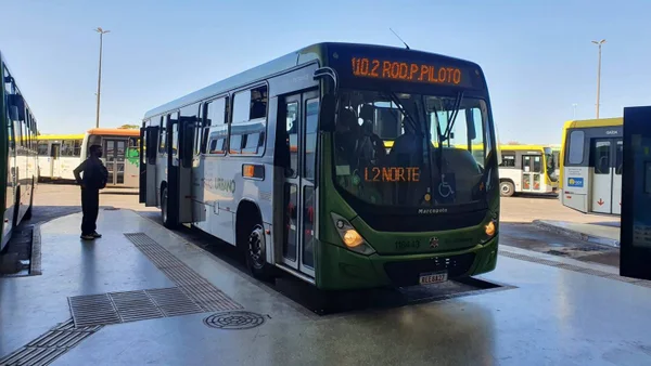 Foto colorida de ônibus verde em plataforma de terminal rodoviário. No letreiro está escrito: 110.2 UNB