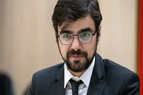 Imagem colorida de Guilherme Melo, secretário de Política Econômica do Ministério da Fazenda. Ele veste terno escuro, camisa clara, usa grava e óculos - Metrópoles