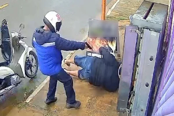 Imagem colorida, homem dando tiros em outro homem que está no chão - Metrópoles