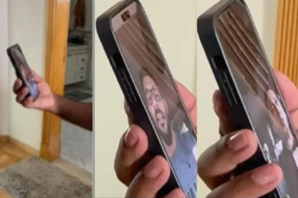 Mão masculina, de homem branco, segura celular em ligaçõa de vídeo - Metrópoles