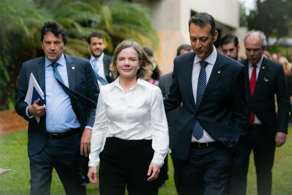 A presidente do PT e membro do governo de transição do presidente eleito Lula, Gleisi Hoffmann, fala em coletiva de imprensa ao ladoe de Aloizio Mercadante e outros políticos. Sorrindo, ela caminha em frente ao Centro Cultural Banco do Brasil, onde ocorre o evento - Metrópoles