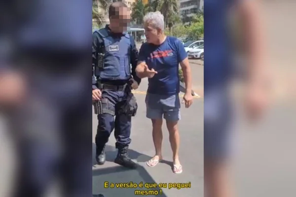 Frame de imagem colorida de um policial militar fardado ao lado de um civil com cabelo grisalho - Metrópoles
