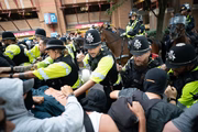 Policiais montados entram em confronto com manifestantes durante protesto do grupo “Abolish Asylum System” e de contramanifestantes em Castle Park, em Bristol.