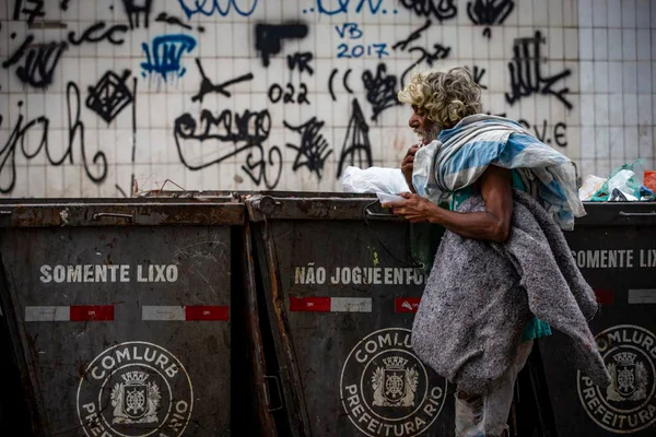homem pega comida no lixo