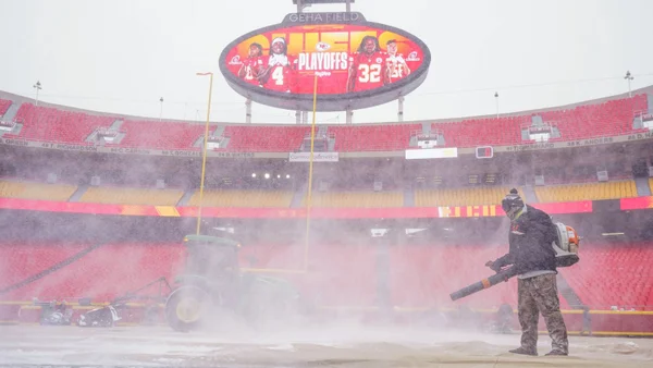 Imagem colorida de homem tirando neve em estádio -metrópoles
