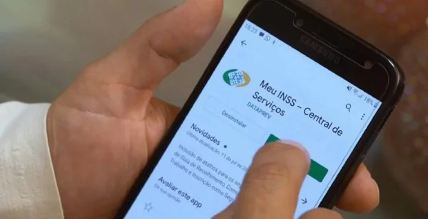 pessoa usa o celular para consultar informações no aplicativo do INSS