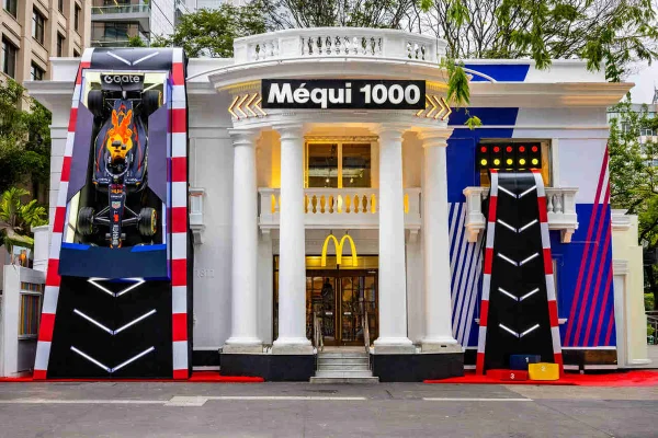Frente do Mequi 1000, na Avenida Paulista, decorado com alução à Fórmula 1, tem um carro da Red Bull pendurado.