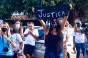 Mulher ergue placa pedindo justiça após mortes na Chapada