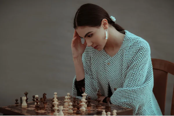 Jovem mulher raciocinando em jogo de xadrez - Metrópoles