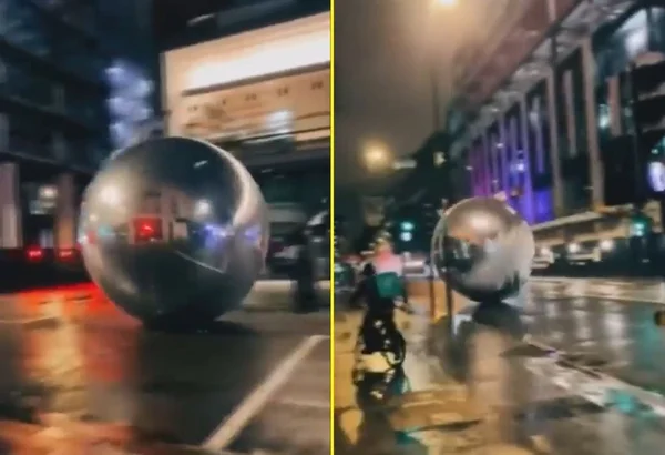 foto colorida de bola de natal enorme rolando pela rua