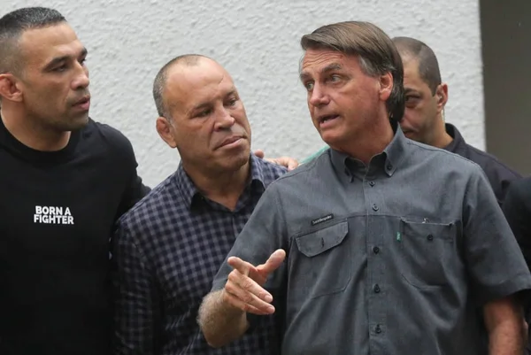 Bolsonaro ao lado de lutadores que declararam apoio à sua campanha em São Paulo. Ele aponta para frente e fala com Werdum e Vanderlei Silva, ao seu lado - Metrópoles