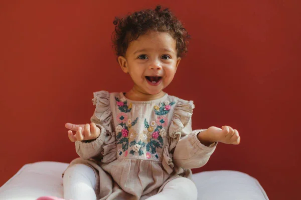 na foto temos uma menina de pele negra que sorri