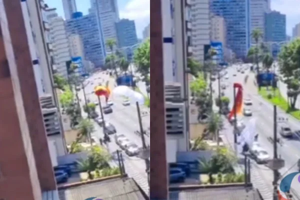 Morador de São Vicente flagrou o momento em que o piloto do paraglider caiu e se enroscou no poste. Energia elétrica não foi afetada - Metrópoles
