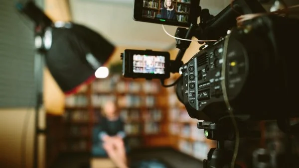 Pessoa sendo entrevistada com câmera para canal audiovisual