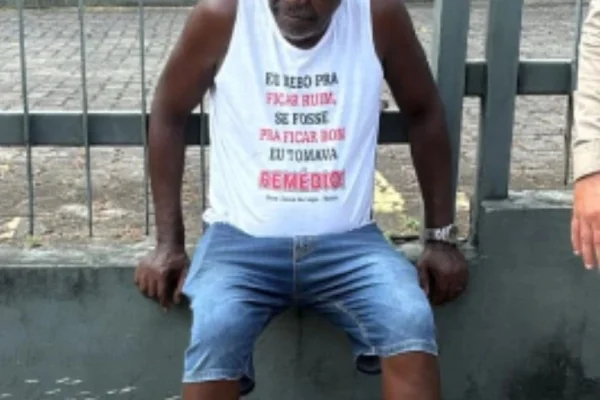 Imagem colorida de motorista usando camisa com estampa "bebo pra ficar ruim" - Metrópoles