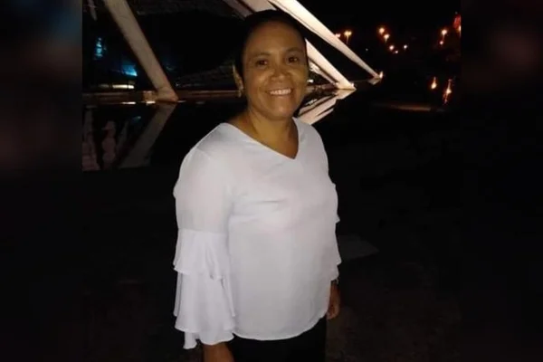 Mulher usando blusa branca e calça preta. Ela está com os cabelos pretos presos- Metrópoles