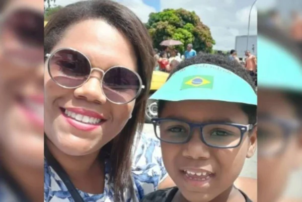 foto colorida de menino negro de oculos e mulher negra de oculos escuros sorrindo ao lado dele - metrópoles