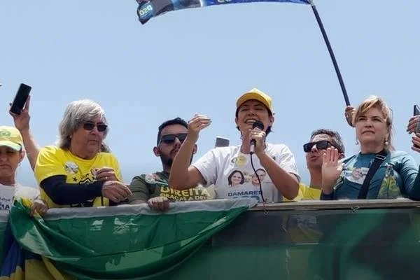 Fotografia colorida de grupo de pessoas em cima de trio elétrico