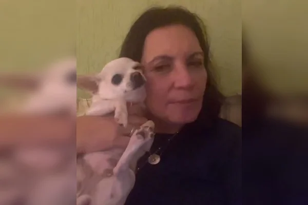 Fotografia colorida de mulher ao lado de cachorro branco