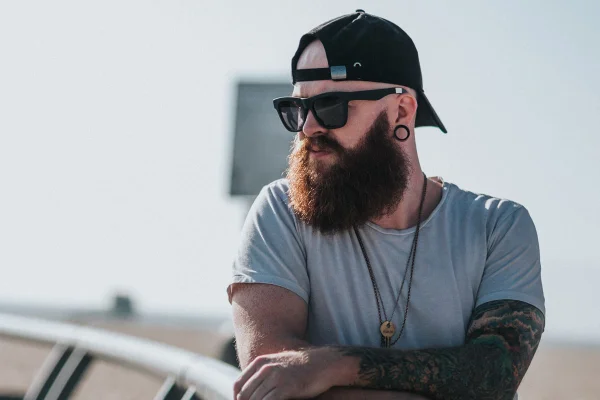 homem de barba e óculos escuros
