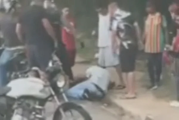 Imagem colorida de pelo menos 8 homens ao redor de um homem jogado na calçada. Homem espancado morreu - Metrópoles