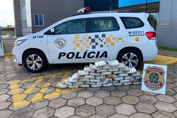 Imagem colorida mostra viatura de polícia e vários pacotes de skank apreendidos com homem em fiscalização em rodovia no interior de São Paulo - Metrópoles