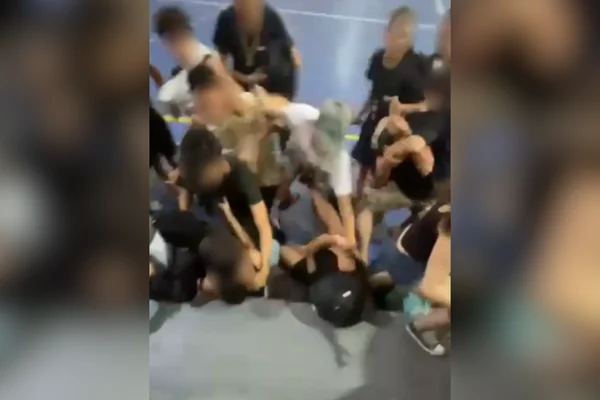 Imagem colorida de alunos brigando. Metrópoles