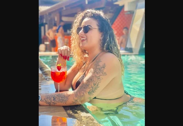 Mulher de óculos escuros, na piscina, bebendo drink - Metrópoles