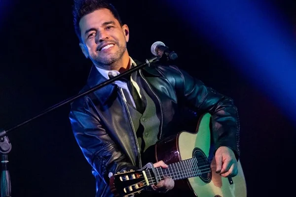 Zezé Di Camargo posa durante show com violão - Metrópoles