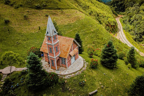 Foto colorida de edificação de casa em meio a área verde - Metrópoles